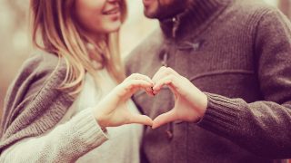 loving couple showing heart for valentine day on cozy walk